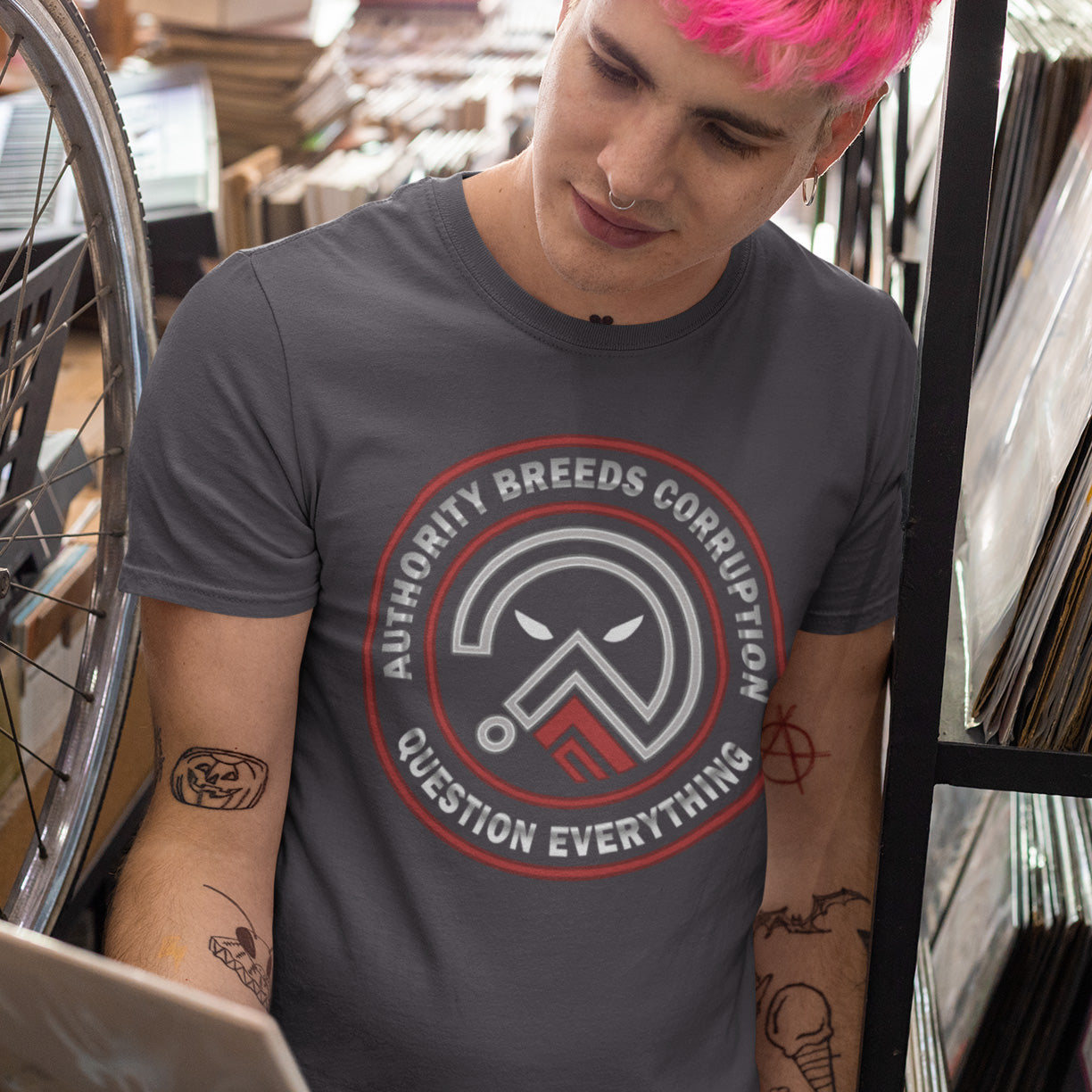 Person wearing a t-shirt standing in a store. A question everything t shirt for everyday defiance or leading the next protest rally. Help create social awareness of the dark side of human nature, how power corrupts and authority is abused. To be worn with pride in support of a world where authority should be answerable to the people who put them there. Made from 100% organic ring-spun cotton, this broken society t shirt is unisex, high quality, super comfy, and best of all, eco-friendly.
