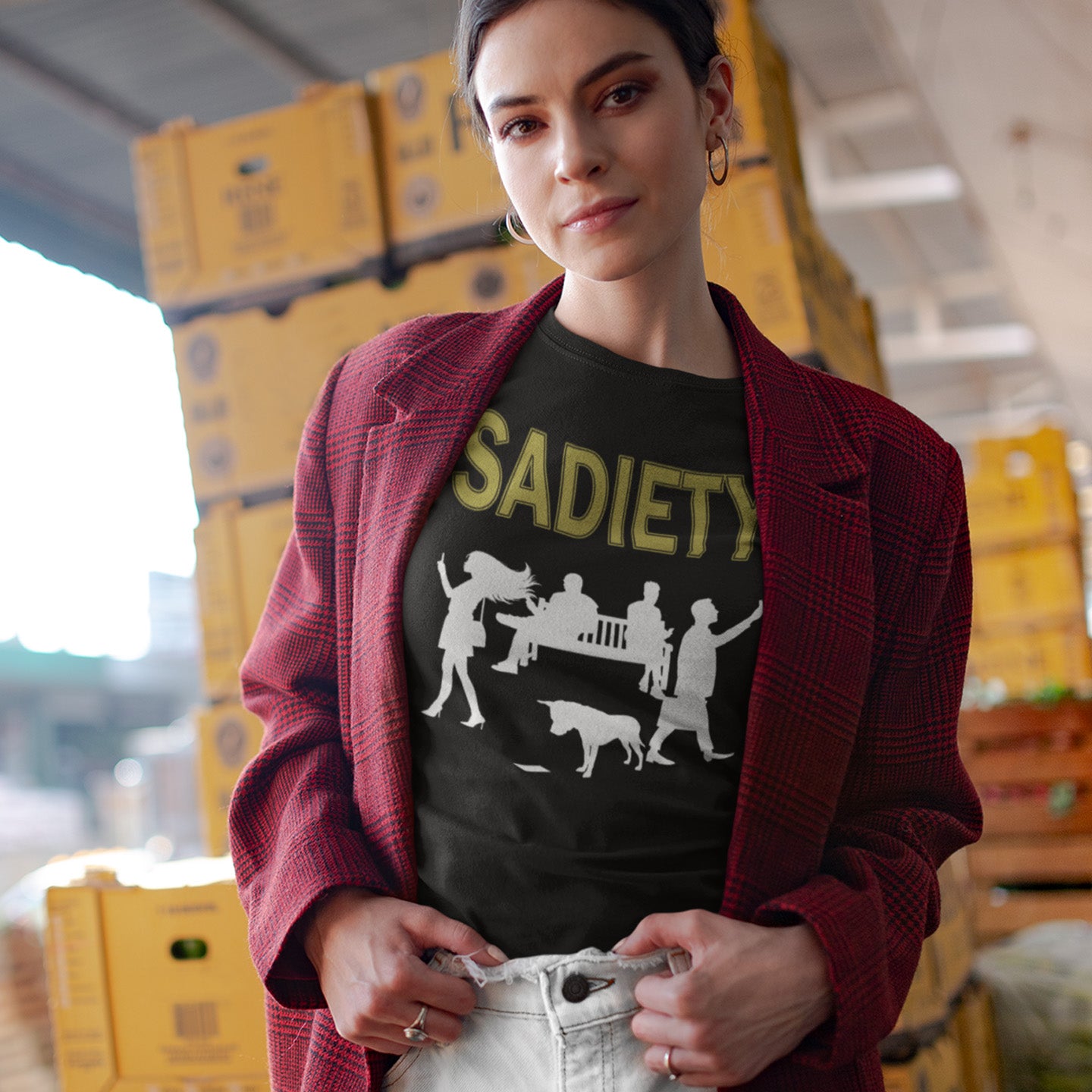 Person wearing a black t-shirt with graphic design and text, standing in an indoor setting with boxes in the background. A counterculture t-shirt design promoting social awareness about the effects of the mobile phone on society and sociability. The mobile phone has made people in close proximity seem miles apart. It's not a society, it's sadiety. Made from 100% organic ring-spun cotton, this subculture t-shirt is unisex, high-quality, super comfy, and best of all, eco-friendly.