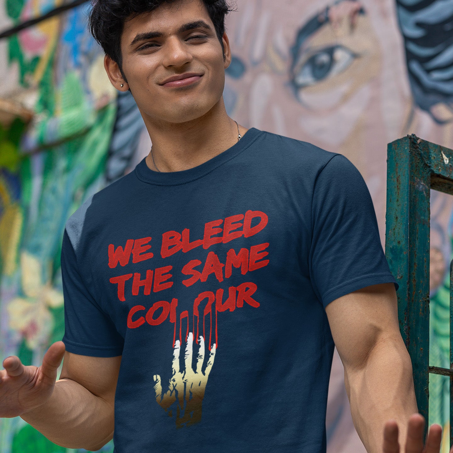 Man wearing a French navy blue t-shirt with red text in front of a colourful mural. This anti racism t-shirt design highlights how shallow racism is. show you stand against prejudice with this street style urban art on apparel. Made from 100% organic ring-spun cotton, this social awareness anti racism t shirt is unisex, high-quality, super comfy, and best of all, eco-friendly.