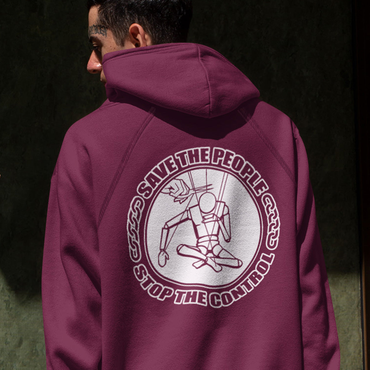 Person wearing a burgundy hoodie with a graphic design on the back against a dark background. This political hoodie carries an anti-dictatorship message and encourages independent thought. A unique design promoting freedom of choice and a less controlling government. Comfortable and practical. It's extra soft and has a convenient front pouch pocket. Made from organic cotton and recycled polyester, this political hoodie is a great eco-friendly choice.