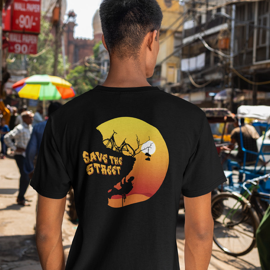 Person wearing a black t-shirt with 'Save the Street' graphic on a busy street. A street art t shirt design paying homage to street life. As our society increasingly turns to an online based community it's worth giving a shout out to where the real community is based, on the streets! Let's keep them full of life. Made from 100% organic ring-spun cotton, these street art t shirts are unisex, high quality, super comfy, and best of all, eco-friendly.