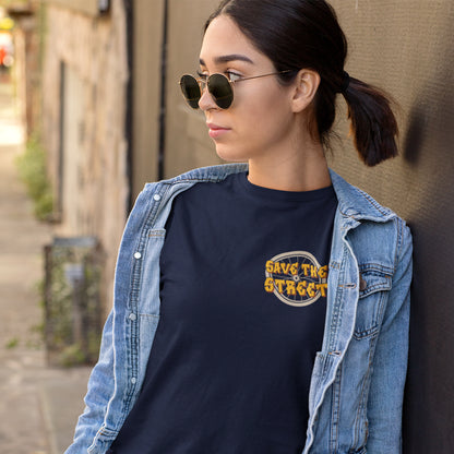 Woman wearing sunglasses and a denim jacket with a dark shirt featuring 'Save the Streets' text. A street art t shirt design paying homage to street life. As our society increasingly turns to an online based community it's worth giving a shout out to where the real community is based, on the streets! Let's keep them full of life. Made from 100% organic ring-spun cotton, these street art t shirts are unisex, high quality, super comfy, and best of all, eco-friendly.