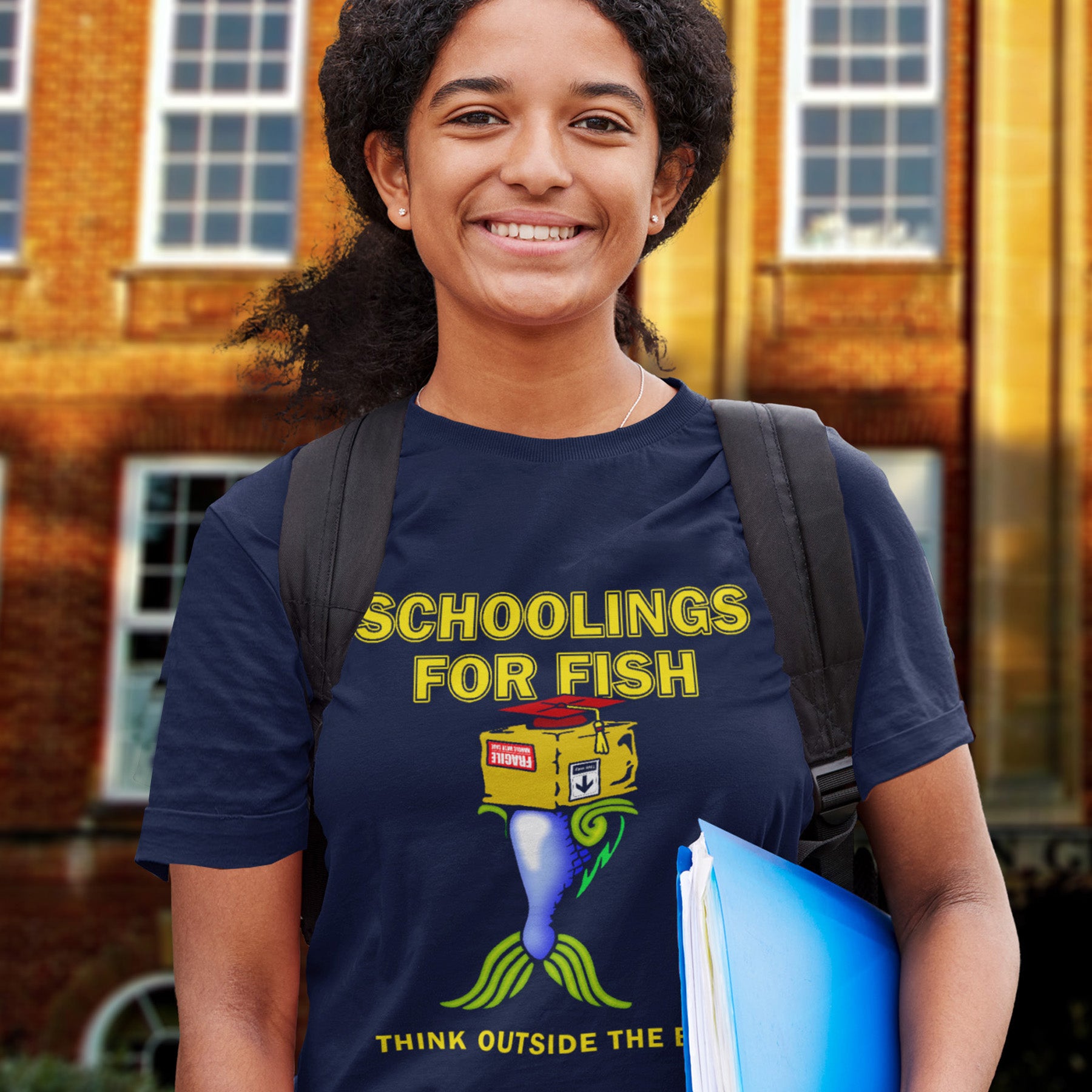 Person wearing a French navy t-shirt with a colourful graphic and text, standing in front of a brick building. This alternative educational t-shirt design conveys a feeling that we are not quite being taught the full picture by our educational system. Great choice for any disgruntled student. Made from 100% organic ring-spun cotton, this witty counterculture t-shirt is unisex, high-quality, super comfy, and best of all, eco-friendly.