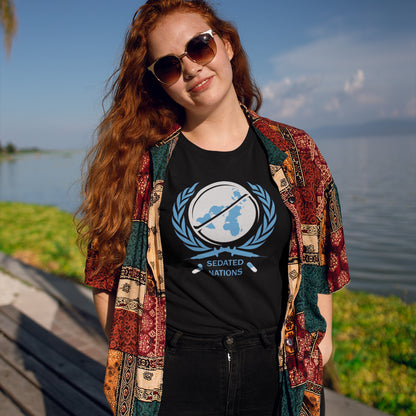 Woman wearing a black t shirt with 'sedated nations' logo, standing near a lake. This anti drugs t shirt suggests an overuse of pharmaceutical drugs in the developed world. Are we united or just overly sedated ? A very satirical view questioning the effects of capitalism on the health care pharmaceutical industry. Made from 100% organic ring-spun cotton, this counter culture t shirt is unisex, high quality, super comfy, and best of all, eco-friendly.