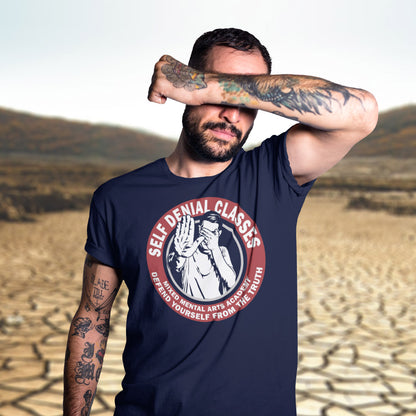 Man wearing a navy blue t-shirt with a graphic design in a desert setting. This emotional intelligence t shirt satirically highlights self denial as an increasing part of everyday life and suggests we could provide classes to improve it. This sarcastic urban art design laughs at people who want to protect themselves from the truth. Made from 100% organic ring-spun cotton, this broken society t shirt is unisex, high-quality, super comfy, and best of all, eco-friendly.