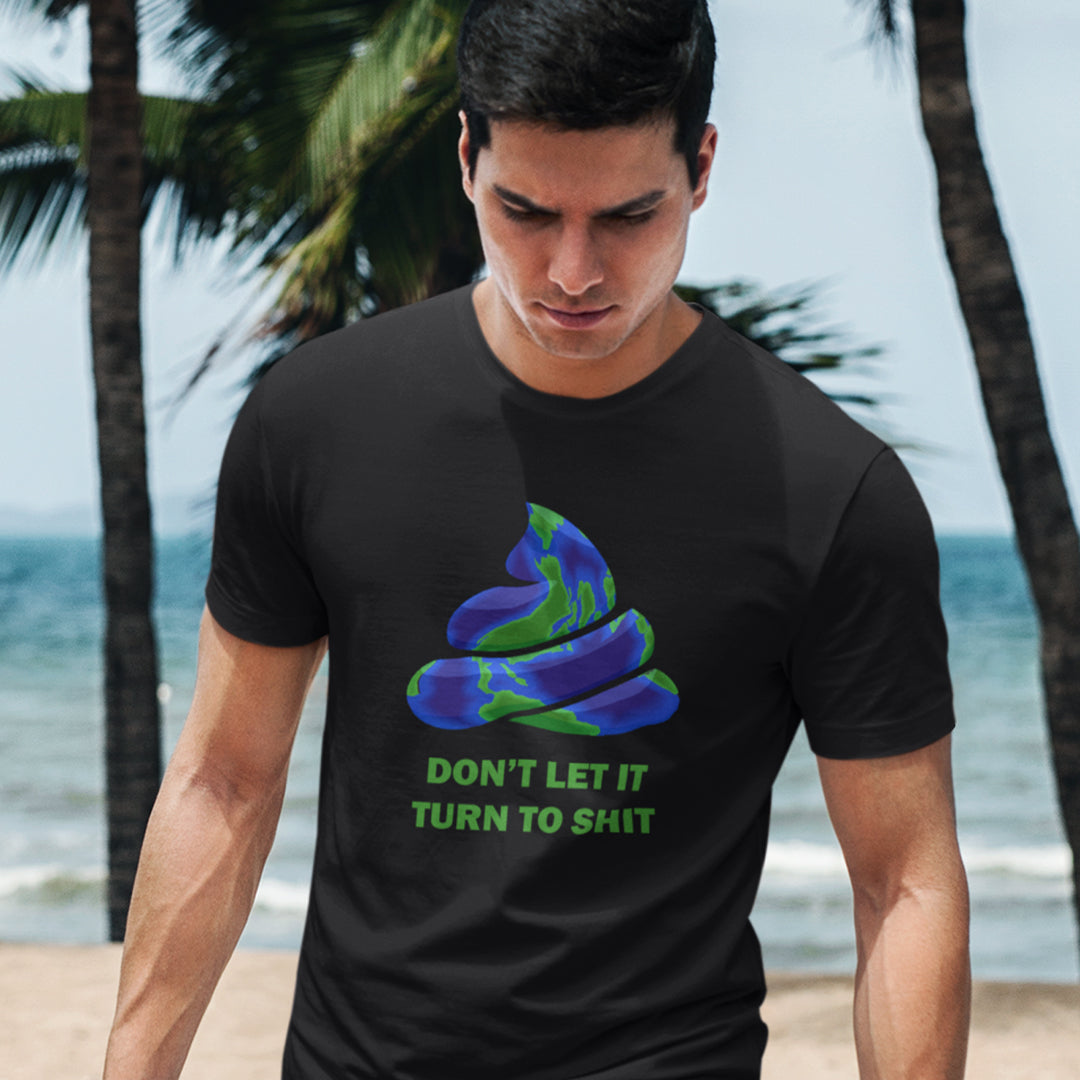 A man on a beach staring down, wearing a black t-shirt featuring a graphic of a swirling poop emoji with a blue and green globe pattern, above the text 'DON'T LET IT TURN TO SHIT' in green.