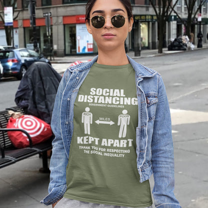 Person wearing a khaki t-shirt with social distancing message on a city street. An anti government t shirt design representing a much older form of social distancing in our society. Class inequality. This anti establishment t-shirt design promote social awareness of the class divide our system creates. Made from 100% organic ring-spun cotton, this non conformist t shirt is unisex, high-quality, super comfy, and best of all, eco-friendly.
