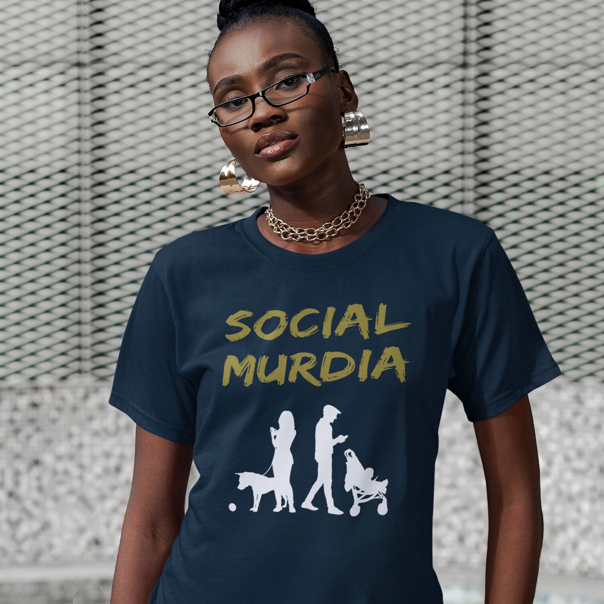 Person wearing a navy blue t-shirt with 'SOCIAL MURDIA' text. An anti-social media t-shirt arguing against the abuse of social media and mobile phones. The main aim of social media is to connect people, but it doesn't look like that from street level. This anti-mobile phone design suggests society is actually being murdered by media on mobiles. Made from 100% organic ring-spun cotton, this social awareness t-shirt is unisex, high-quality, super comfy, and best of all, eco-friendly.