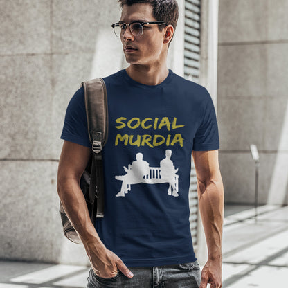 Man wearing a navy blue t-shirt with 'SOCIAL MURDIA' text and graphic, standing against a concrete wall. An anti-social media t-shirt arguing against the abuse of social media and mobile phones.  This anti-mobile phone design suggests society is actually being murdered by media on mobiles. Made from 100% organic ring-spun cotton, this anti-social media t-shirt is unisex, high-quality, super comfy, and best of all, eco-friendly.
