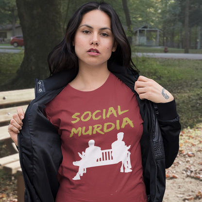 Woman wearing a burgundy t-shirt with 'SOCIAL MURDIA' text and graphic outdoors. An anti-social media t-shirt arguing against the abuse of social media and mobile phones.  This anti-mobile phone design suggests society is actually being murdered by media on mobiles. Made from 100% organic ring-spun cotton, this anti-social media t-shirt is unisex, high-quality, super comfy, and best of all, eco-friendly.