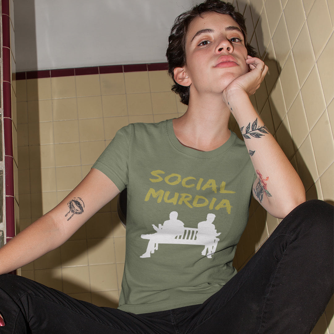 Person wearing a green t-shirt with 'SOCIAL MURDIA' text. An anti mobile phone abuse t shirt arguing against the abuse of social media and mobile phones. The main aim of social media is to connect people, but it doesn't look like that from street level. This anti-mobile phone design suggests society is actually being murdered by media on mobiles. Made from 100% organic ring-spun cotton, this anti social media t shirt is unisex, high-quality, super comfy, and best of all, eco-friendly.