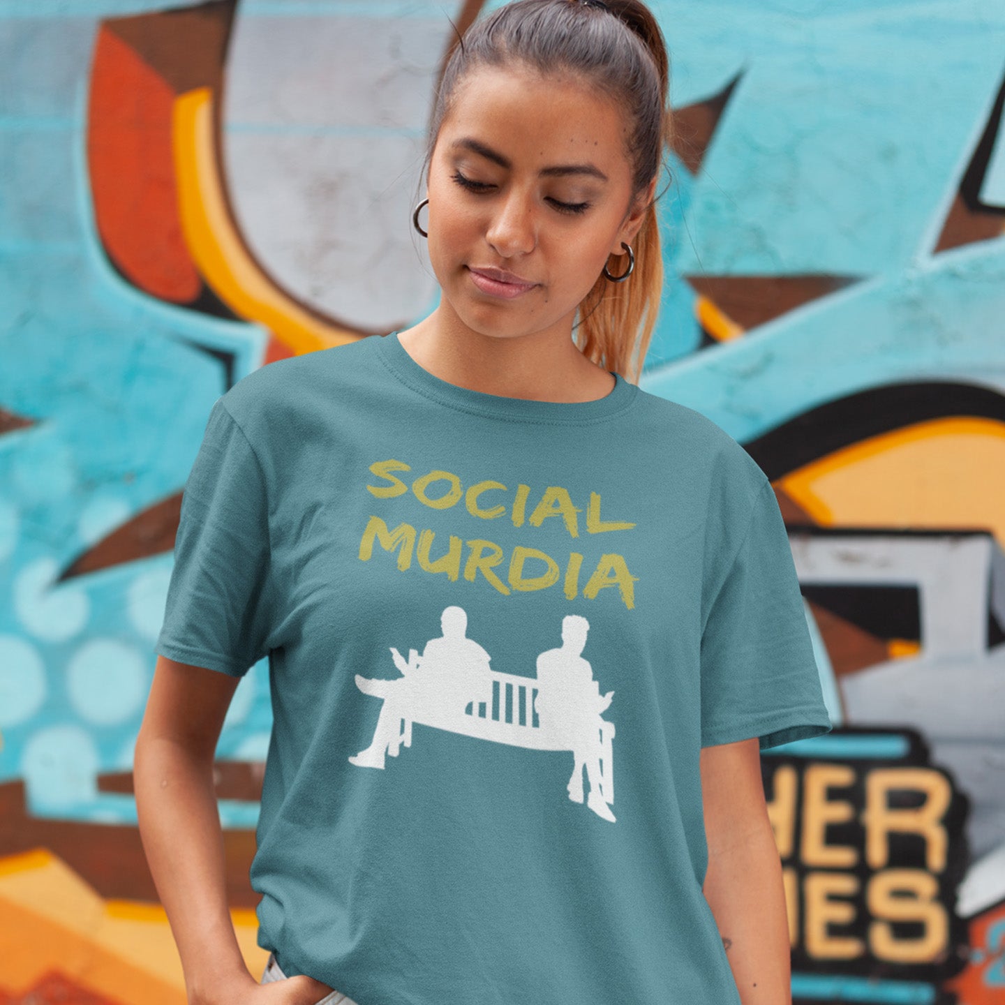 Person wearing a stargazer t-shirt with 'SOCIAL MURDIA' text and graphic, standing in front of a colourful mural. An anti-social media t-shirt arguing against the abuse of social media and mobile phones.  This anti-mobile phone design suggests society is actually being murdered by media on mobiles. Made from 100% organic ring-spun cotton, this anti-social media t-shirt is unisex, high-quality, super comfy, and best of all, eco-friendly.