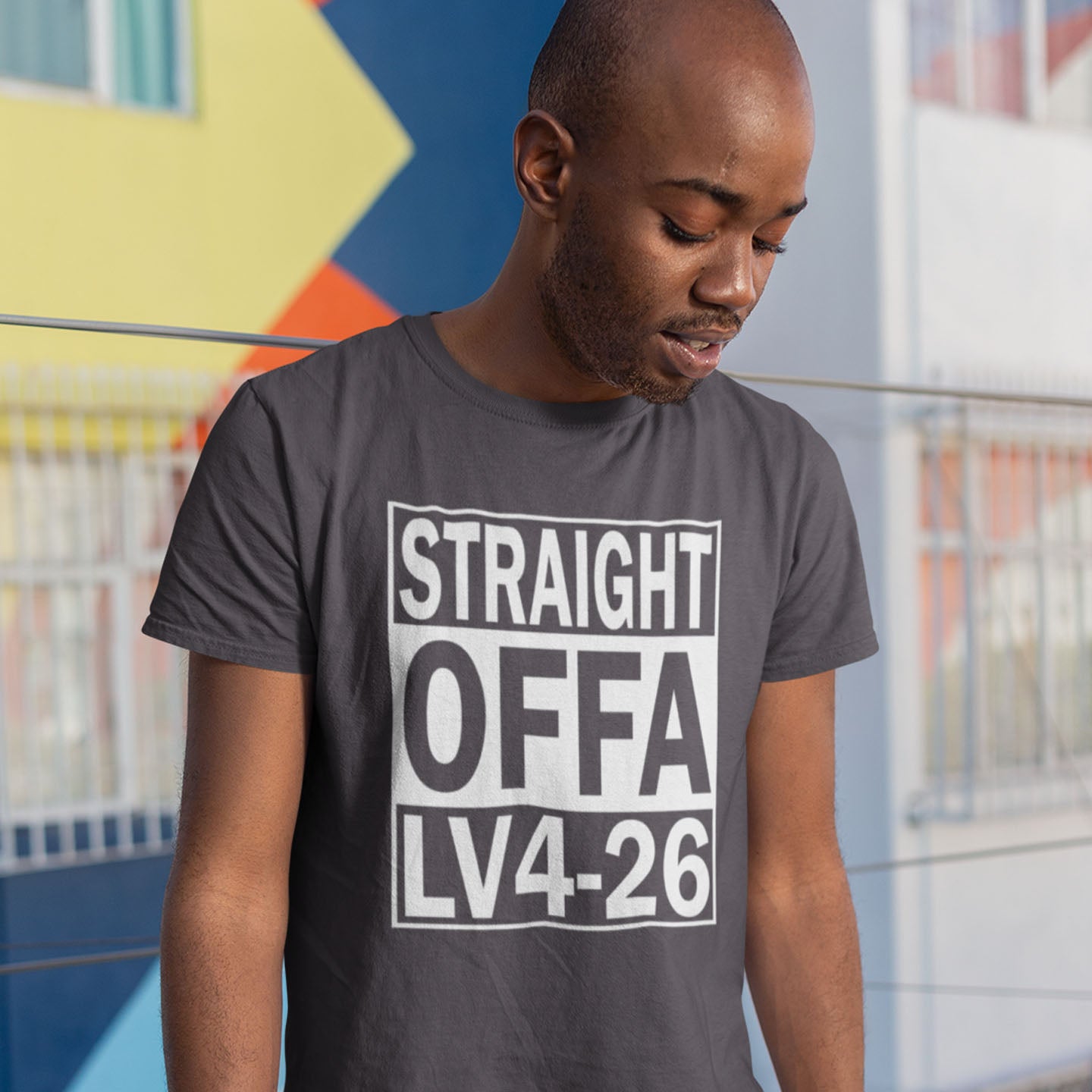 Man wearing an anthracite t-shirt with text in an urban setting. This 'Alien' the movie t-shirt is subtle and loud at the same time' A design for fans of N.W.A and Alien movie lovers. Made from 100% organic ring-spun cotton, this witty sci-fi t-shirt is unisex, high-quality, super comfy, and best of all, eco-friendly.
