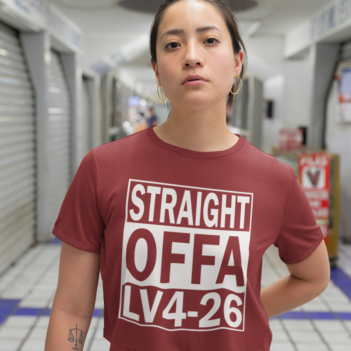 Person wearing a burgundy t-shirt with text in a store setting. This 'Alien' the movie t-shirt is subtle and loud at the same time' A design for fans of N.W.A and Alien movie lovers. Made from 100% organic ring-spun cotton, this witty sci-fi t-shirt is unisex, high-quality, super comfy, and best of all, eco-friendly.