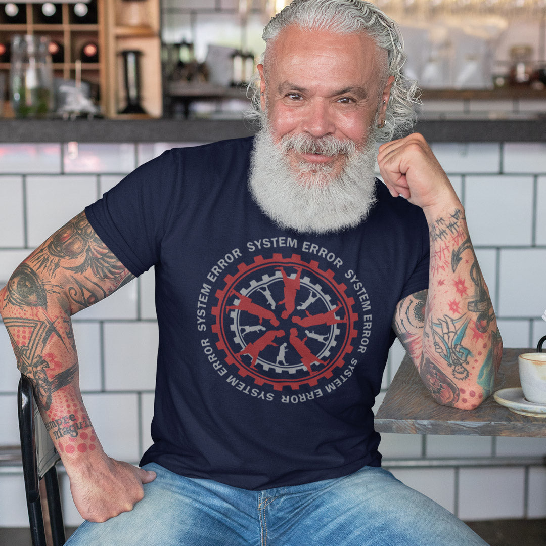 Man with tattoos wearing a navy blue t-shirt with a red and white graphic design in a kitchen. An anti corporate t shirt design for people who want more out of life than a well oiled machine for soulless robots. This system error t shirt warns that it's the whole system that is the problem not the details. Made from 100% organic ring-spun cotton, this anti corporate t shirt is unisex, high-quality, super comfy, and best of all, eco-friendly.