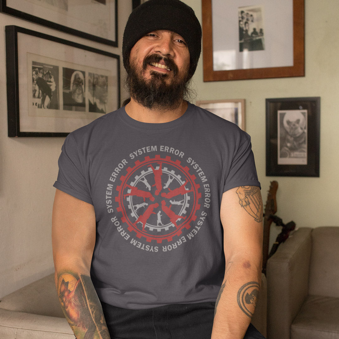 Man wearing a t-shirt with a red and grey gear design in a room with framed pictures on the wall. An anti corporate t shirt design for people who want more out of life than a well oiled machine for soulless robots. This system error t shirt warns that it's the whole system that is the problem not the details. Made from 100% organic ring-spun cotton, this anti corporate t shirt is unisex, high-quality, super comfy, and best of all, eco-friendly.