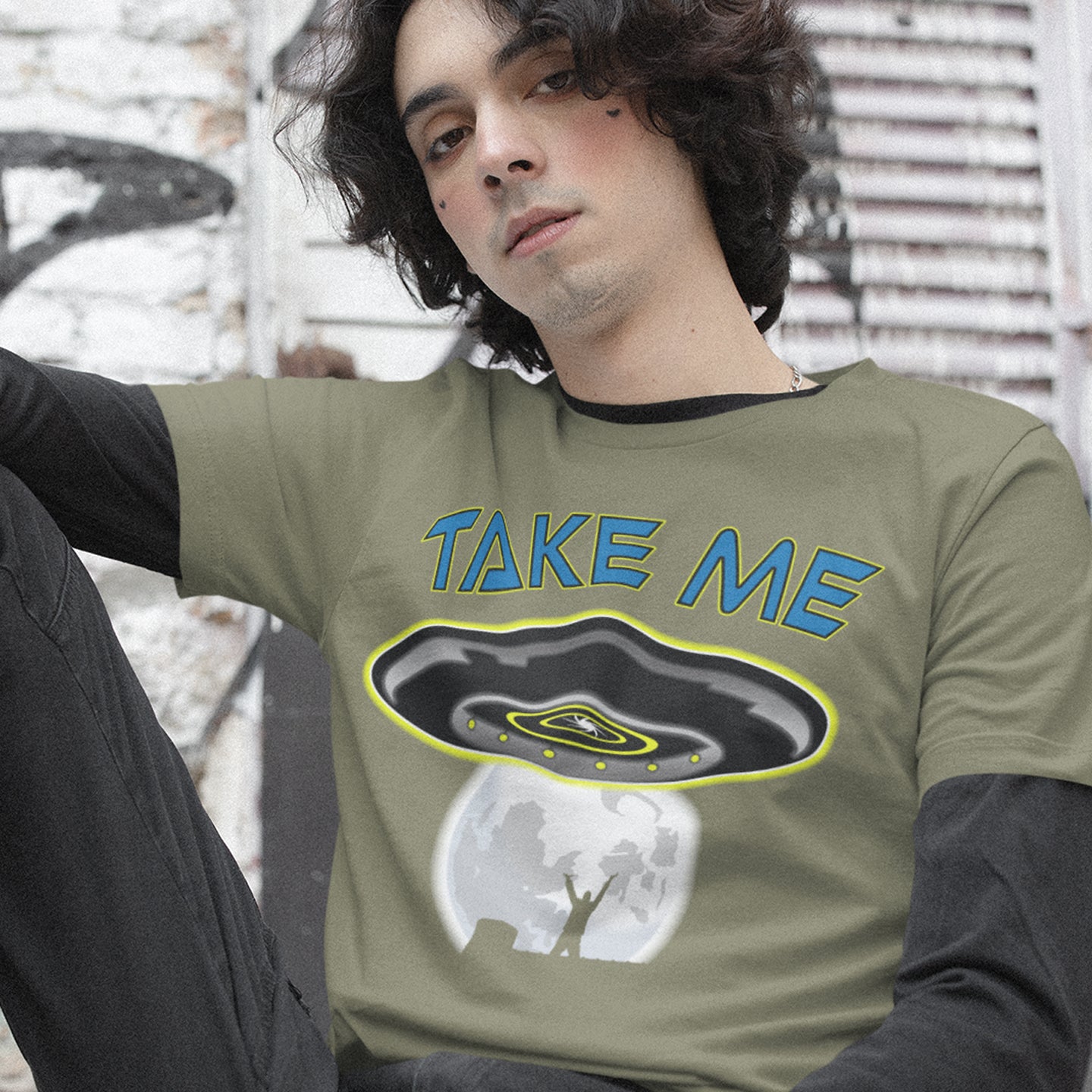Person wearing a khaki sweatshirt with 'TAKE ME' and UFO graphic. This funny alien abduction t-shirt is a must for everyone who feels they have you had enough of this planet or, more to the point, the human race. Do you sometimes think you would be better off being abducted ? Made from 100% organic ring-spun cotton, this funny sci fi t-shirt is unisex, high-quality, super comfy, and best of all, eco-friendly.