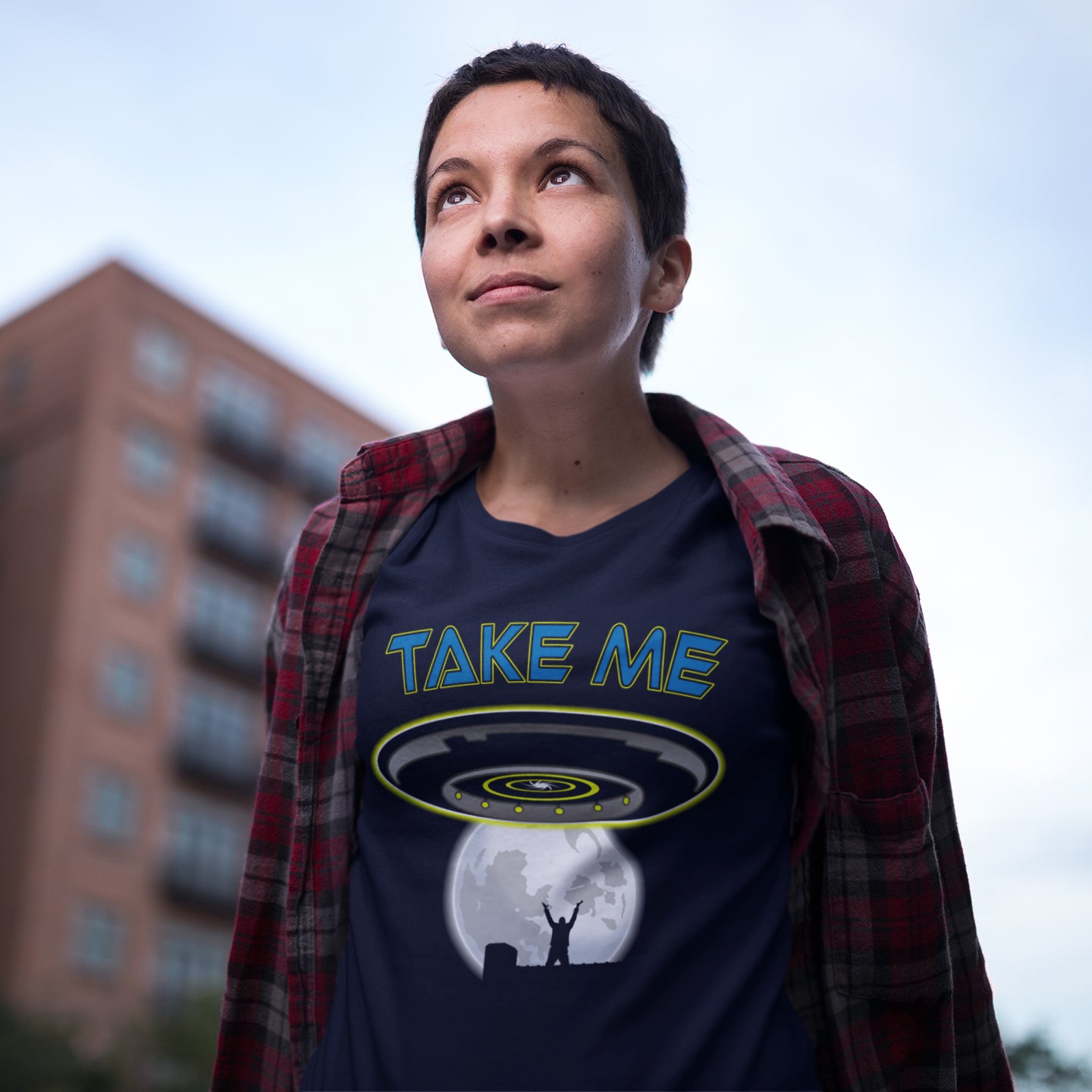 Person wearing a t-shirt with a UFO design and 'Take Me' text, standing outdoors. This alien abduction t shirt is a must for everyone who feels they have you had enough of this planet or, more to the point, the human race. Do you sometimes think you would be better off being abducted ? Made from 100% organic ring-spun cotton, this cool sci fi t shirt is unisex, high-quality, super comfy, and best of all, eco-friendly.