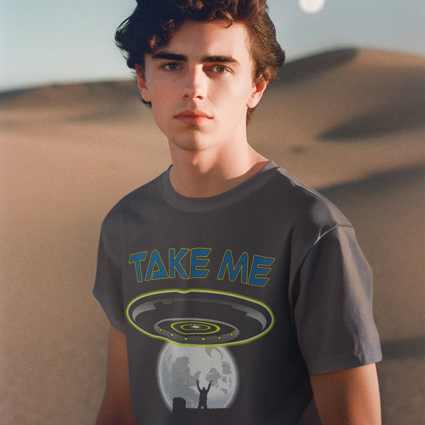 Person wearing a t-shirt with 'Take Me' graphic design in a desert setting. This alien abduction t shirt is a must for everyone who feels they have you had enough of this planet or, more to the point, the human race. Do you sometimes think you would be better off being abducted ? Made from 100% organic ring-spun cotton, this cool sci fi t shirt is unisex, high-quality, super comfy, and best of all, eco-friendly.
