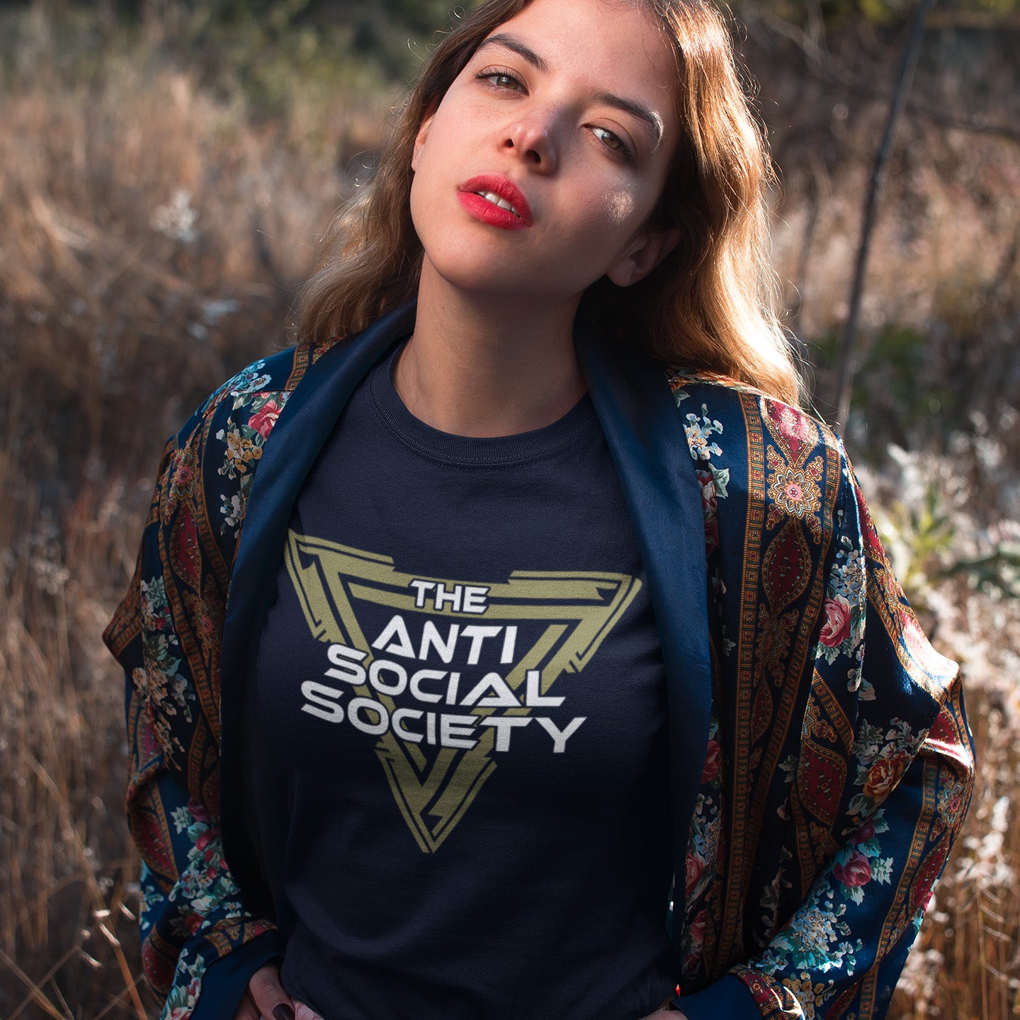 Woman wearing an 'Anti Social Society' t-shirt in a natural setting. This non conformist t shirt design gives you an oxymoron to ponder, the more and more you don't want to be a member, the more you become one. A satirical counterculture dig at modern society. Made from 100% organic ring-spun cotton, this social awareness t-shirt is unisex, high-quality, super comfy, and best of all, eco-friendly.