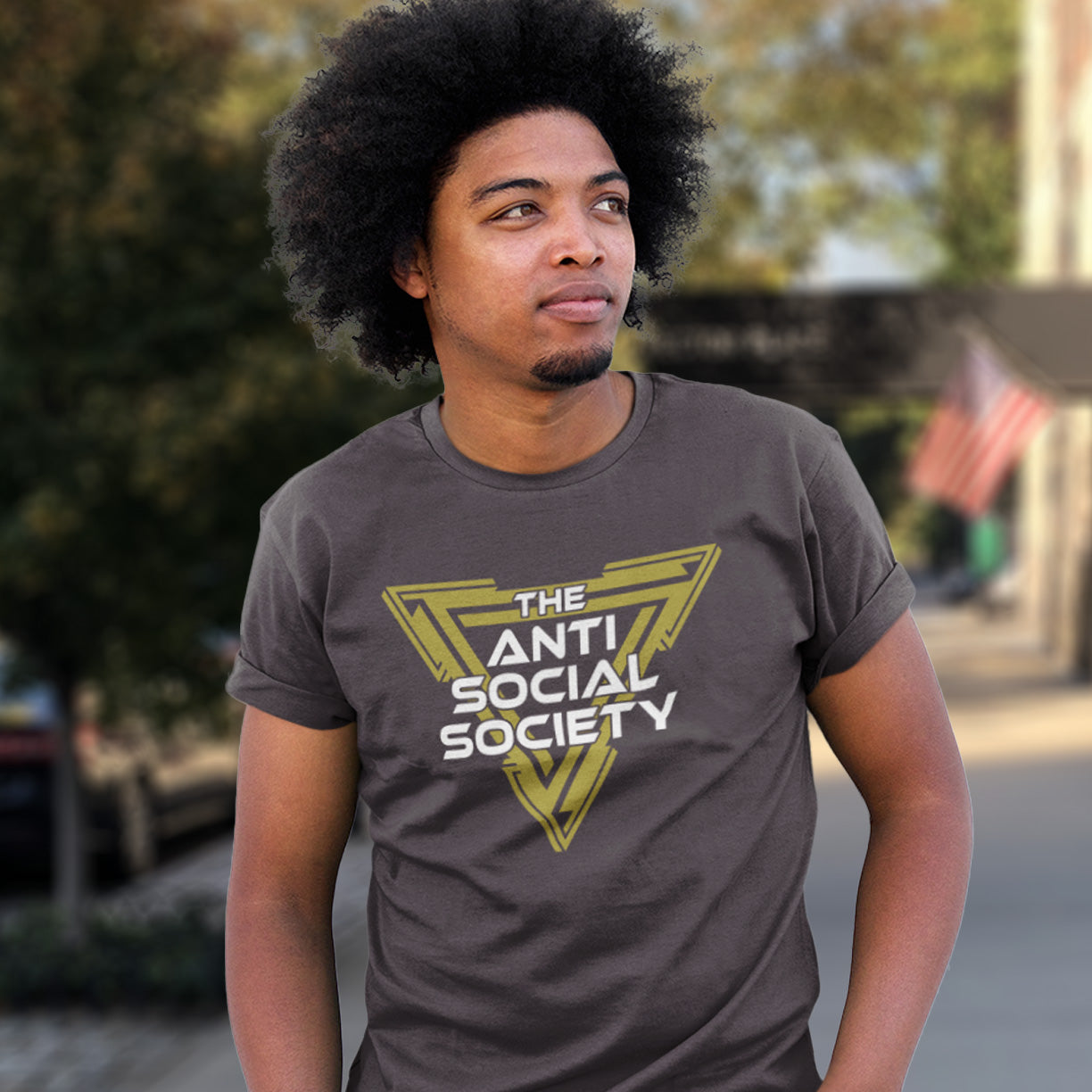 Person wearing a 'The Anti Social Society' t-shirt outdoors. This non conformist t shirt design gives you an oxymoron to ponder, the more and more you don't want to be a member, the more you become one. A satirical counterculture dig at modern society. Made from 100% organic ring-spun cotton, this social awareness t-shirt is unisex, high-quality, super comfy, and best of all, eco-friendly.