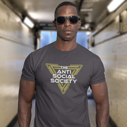 A man wearing an anthracite grey t-shirt with a yellow and white graphic that reads 'THE ANTI SOCIAL SOCIETY' and black sunglasses, standing in a brightly lit hallway.