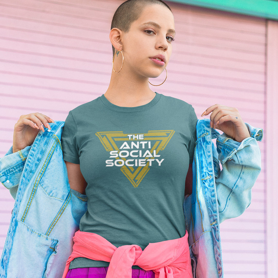A model wearing a stargazer blue t-shirt with a yellow and white graphic that reads 'THE ANTI SOCIAL SOCIETY', holding a light blue denim jacket open on both sides against a pink corrugated metal background.