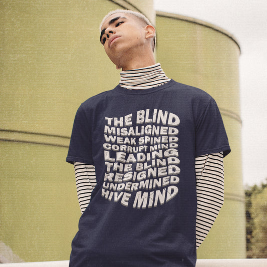 Person wearing a navy blue t-shirt with text in front of a green wall. An anti government t shirt suggesting that it's not just a case of the blind leading the blind anymore. It's now a lot more complicated. Show your social awareness of a dysfunctional society with this political slogan design. Made from 100% organic ring-spun cotton, this dystopian t shirt design is unisex, high-quality, super comfy, and best of all, eco-friendly.