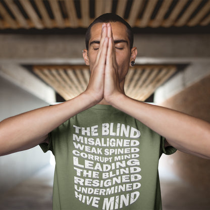 Person wearing a green t-shirt with text, standing with hands pressed together in front of face. An anti government t shirt suggesting that it's not just a case of the blind leading the blind anymore. It's now a lot more complicated. Show your social awareness of a dysfunctional society with this political slogan design. Made from 100% organic ring-spun cotton, this dystopian t shirt design is unisex, high-quality, super comfy, and best of all, eco-friendly.