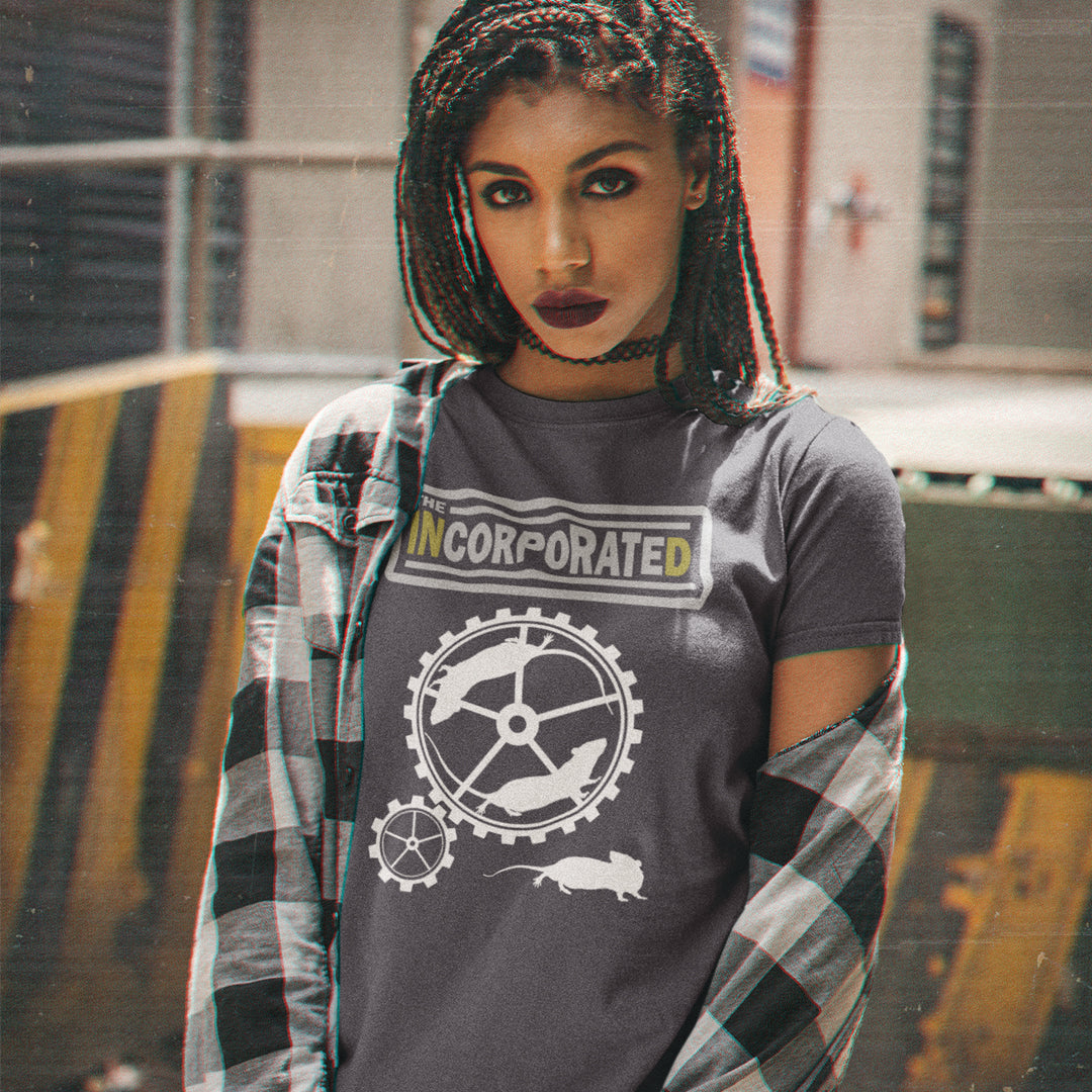 Girl wearing an anthracite t shirt, standing in a loading bay. This non conformist design questions the effects of a corporate run society in the form of a spoof rock band t shirt. Have we just created a corporate cult to follow ? A satirical and alternative view of the modern rat race. Made from 100% organic ring-spun cotton, this counter culture t shirt is unisex, high-quality, super comfy, and best of all, eco-friendly.
