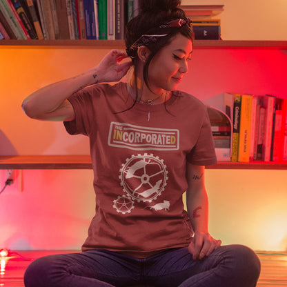 Person wearing a 'The Incorporated' t-shirt in a room with bookshelves. This non conformist t shirt questions the effects of a corporate run society. Have we just created a corporate cult to follow ? A satirical and alternative view of the modern rat race. Made from 100% organic ring-spun cotton, this counter culture t shirt is unisex, high-quality, super comfy, and best of all, eco-friendly.