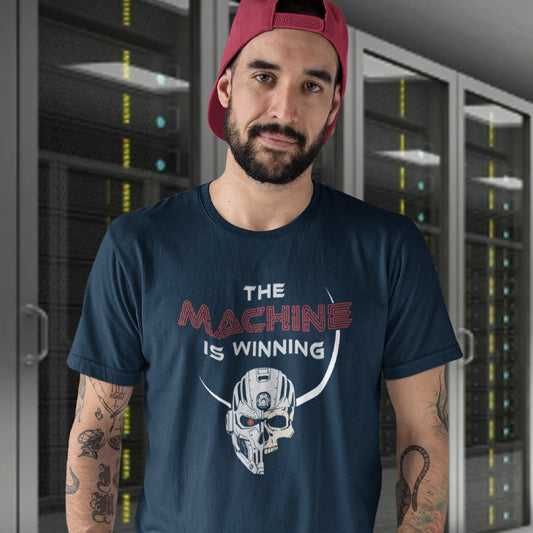Man wearing a French navy blue t-shirt with a graphic design in a server room. This anti ai t shirt design highlights concern for the future of the human race. Show your concern with technological advancement as it threatens to replace the need for humans in more ways than one. Made from 100% organic ring-spun cotton, this counterculture t shirt is unisex, high quality, super comfy, and best of all, eco-friendly.