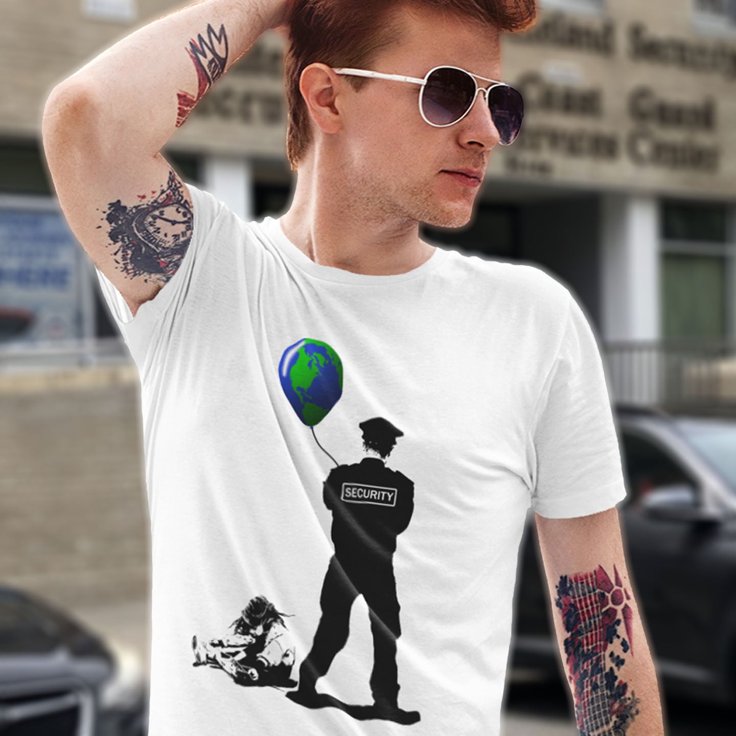 Man wearing a white t-shirt with a graphic design of a security guard holding a globe. A Banksy style graffiti t-shirt with a political message suggesting that we possible left the world in the wrong hands while being distracted. Save the planet by giving it back to the children. Made from 100% organic ring-spun cotton, this graffiti stencil art t-shirt is unisex, high-quality, super comfy, and best of all, eco-friendly.