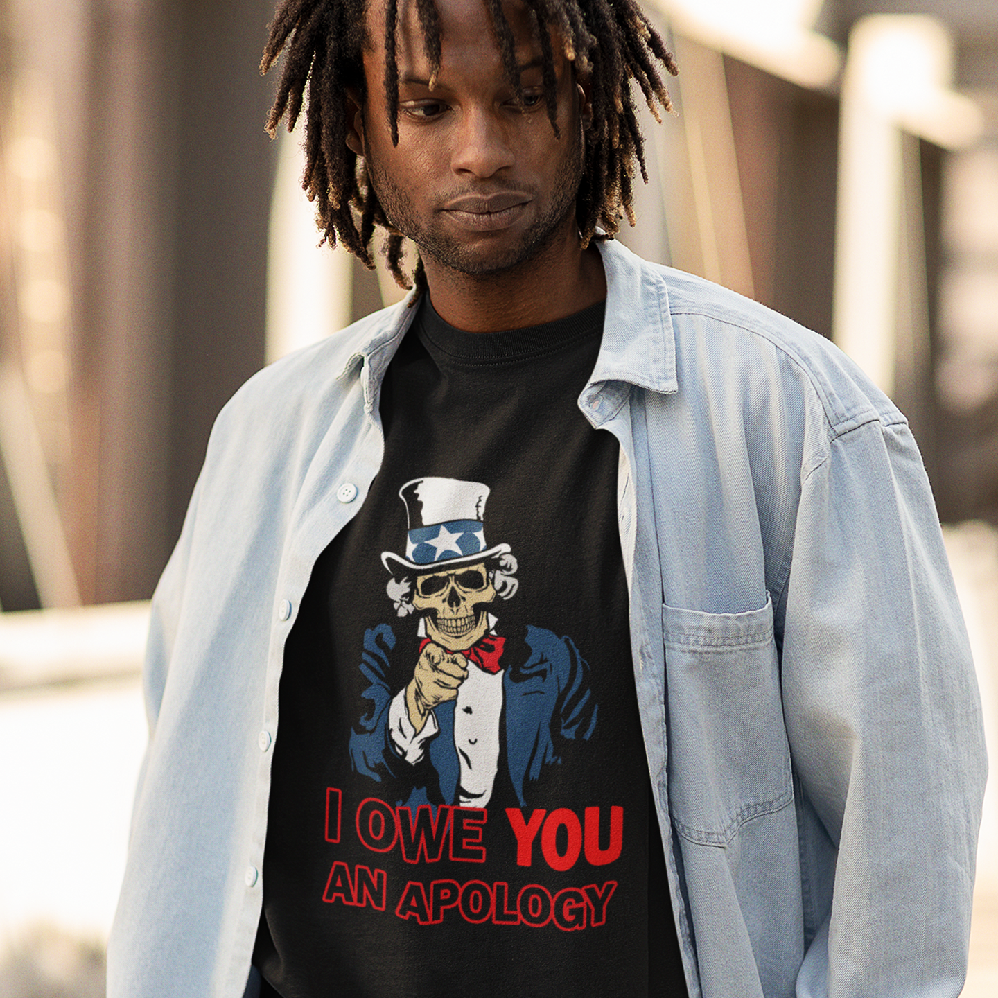 Man wearing a black t-shirt with a graphic design and text, standing outdoors. An anti government t shirt design of Uncle Sam. For too long dark deeds have been done in the name of good people. The government should always answer to the people. Made from 100% organic ring-spun cotton, this non conformist t shirt is unisex, high-quality, super comfy, and best of all, eco-friendly..