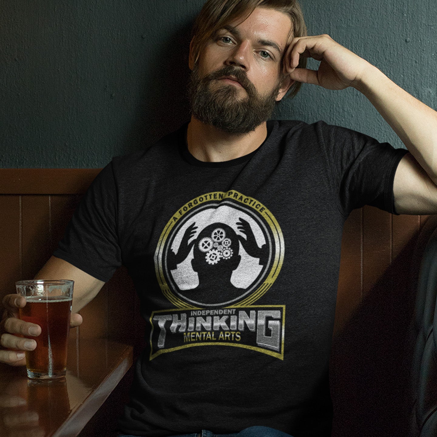 Man wearing a black t-shirt with a graphic design, holding a glass of beer. A sign of the times t shirt suggesting independent thinking is a forgotten art since we let machines think for us. Promote independent thinking with this some what sarcastic t-shirt. Made from 100% organic ring-spun cotton, this urban art t shirt is unisex, high-quality, super comfy, and best of all, eco-friendly.