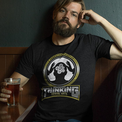 Man wearing a black t-shirt with a graphic design, holding a glass of beer. A sign of the times t shirt suggesting independent thinking is a forgotten art since we let machines think for us. Promote independent thinking with this some what sarcastic t-shirt. Made from 100% organic ring-spun cotton, this urban art t shirt is unisex, high-quality, super comfy, and best of all, eco-friendly.