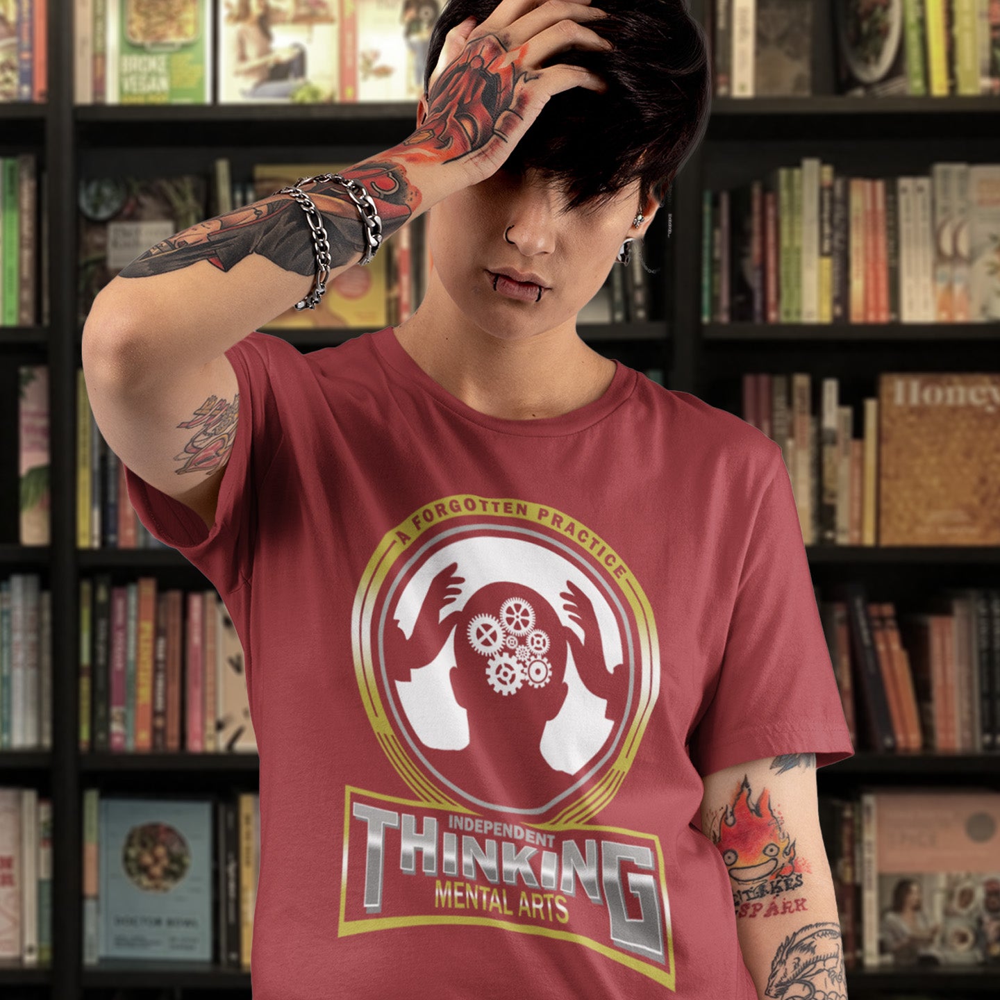 Person wearing a red t-shirt with a graphic design in a library setting. A satirical t-shirt suggesting independent thinking is a forgotten art since we let machines think for us. Promote independent thinking with this some what sarcastic t-shirt. Made from 100% organic ring-spun cotton, this satirical &amp; sarcastic t-shirt is unisex, high-quality, super comfy, and best of all, eco-friendly.