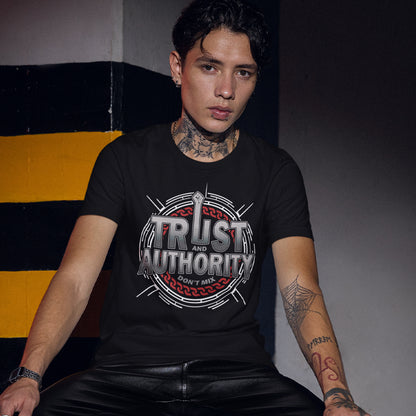 Person wearing a black t-shirt with 'Trust and Authority' design, sitting against a striped background. A broken society t shirt design with trust issues. At first glance this street art design gives the impression of trust for authority, but with a closer look it suggests there is no connection between the two. Made from 100% organic ring-spun cotton, this demo t shirt design is unisex, high quality, super comfy, and best of all, eco-friendly.