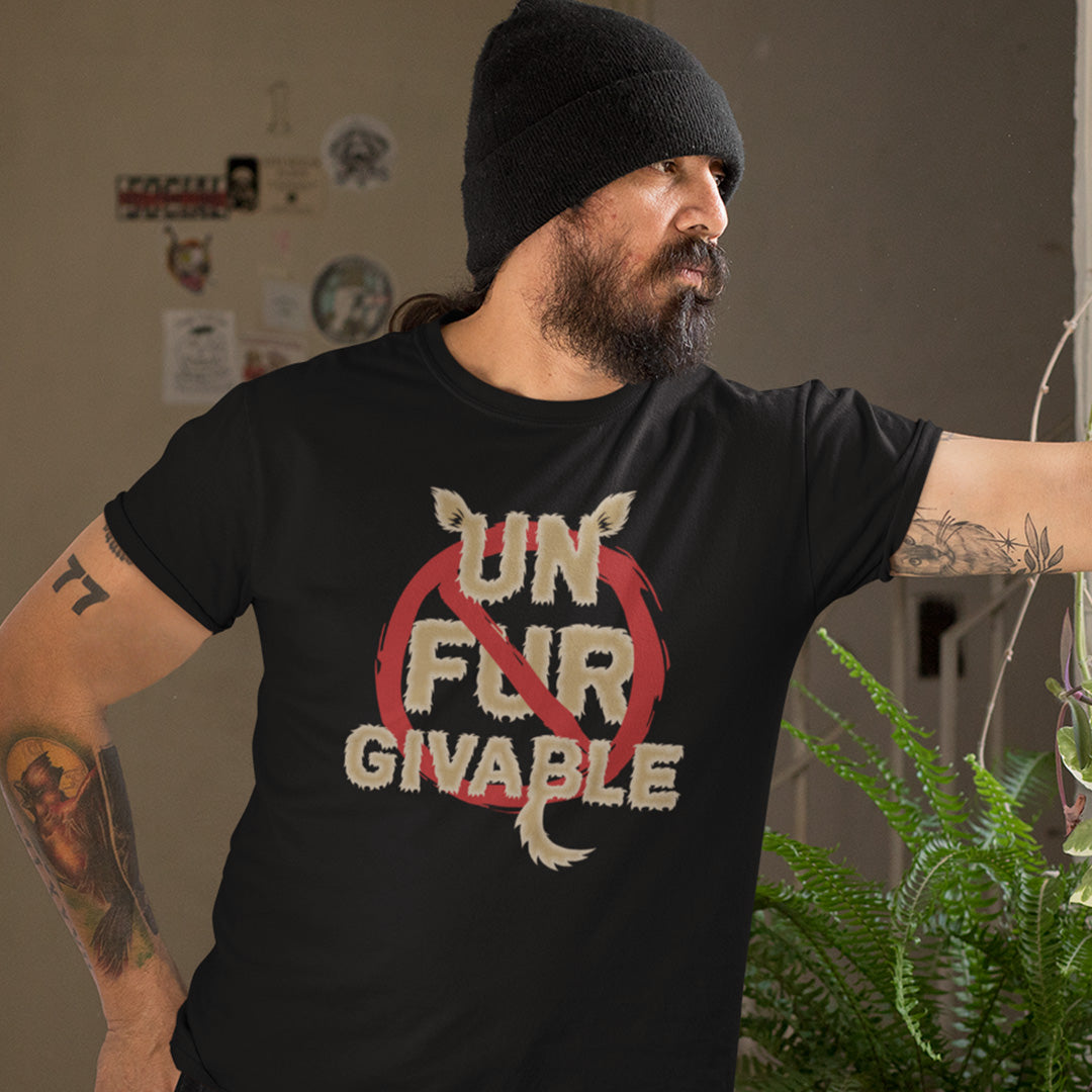 Man wearing a black t-shirt with 'UN FUR GIVABLE' text, standing indoors. This animal rights t shirt is anti fur and suggests the wearing of fur as unforgivable. Show your support against an unnecessary industry that promotes suffering and slaughter. Made from 100% organic ring-spun cotton, these animal activist t shirts are unisex, high-quality, super comfy, and best of all, eco-friendly.