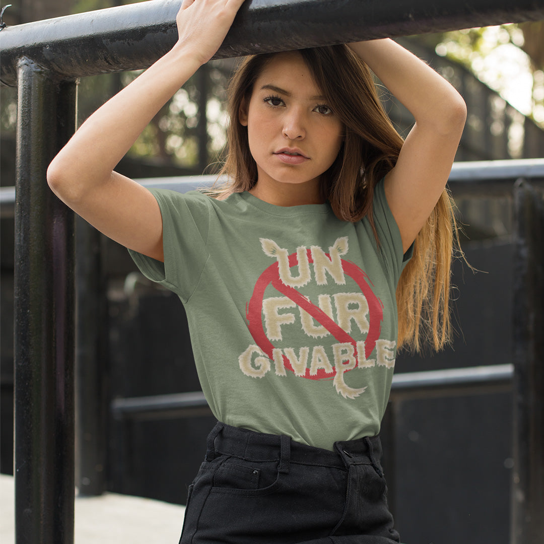 Woman wearing a green t-shirt with a 'Un Fur Givable' design, standing outdoors. This animal rights t shirt is anti fur and suggests the wearing of fur as unforgivable. Show your support against an unnecessary industry that promotes suffering and slaughter. Made from 100% organic ring-spun cotton, these animal activist t shirts are unisex, high-quality, super comfy, and best of all, eco-friendly.
