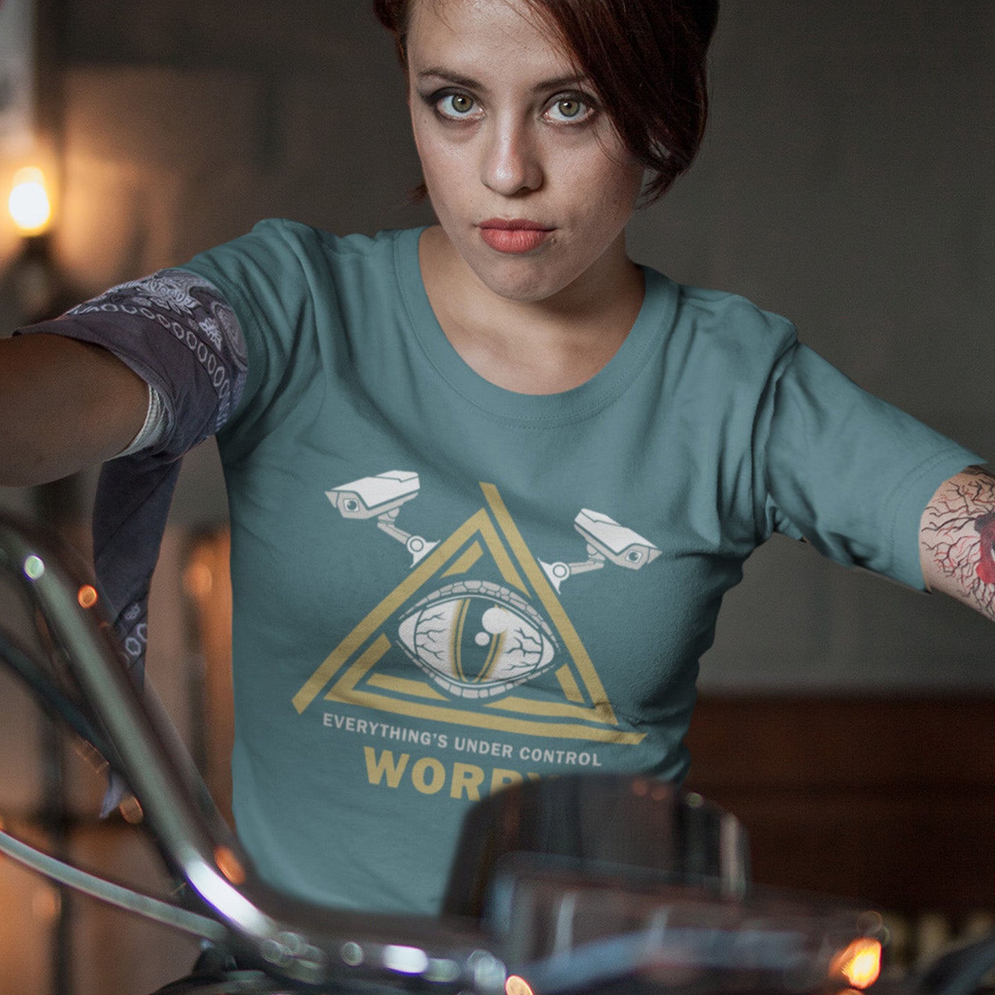 Person wearing a stargazer t-shirt with a graphic design and text, sitting on a motorcycle. A conspiracy theory t-shirt for all that see paranoia as a necessity. This design is a must if your imagination is colourful enough to believe we are being controlled by reptilian alien overlords. Made from 100% organic ring-spun cotton, this alien conspiracy theory t-shirt is unisex, high-quality, super comfy, and best of all, eco-friendly.