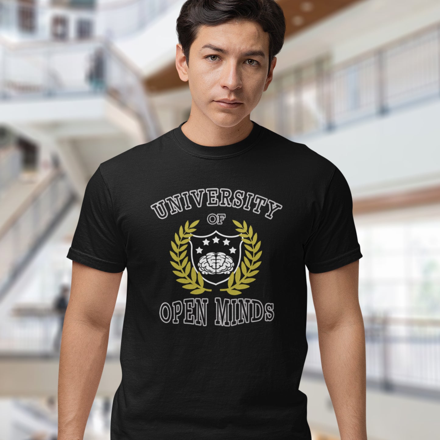 Person wearing a black t-shirt with 'University of Open Minds' design. A cool graphic design for the liberal minded. If you think outside the box then this university is for you. Only practical lessons and no student loan required. Made from 100% organic ring-spun cotton, this social awareness t-shirt is unisex, high-quality, super comfy, and best of all, eco-friendly.