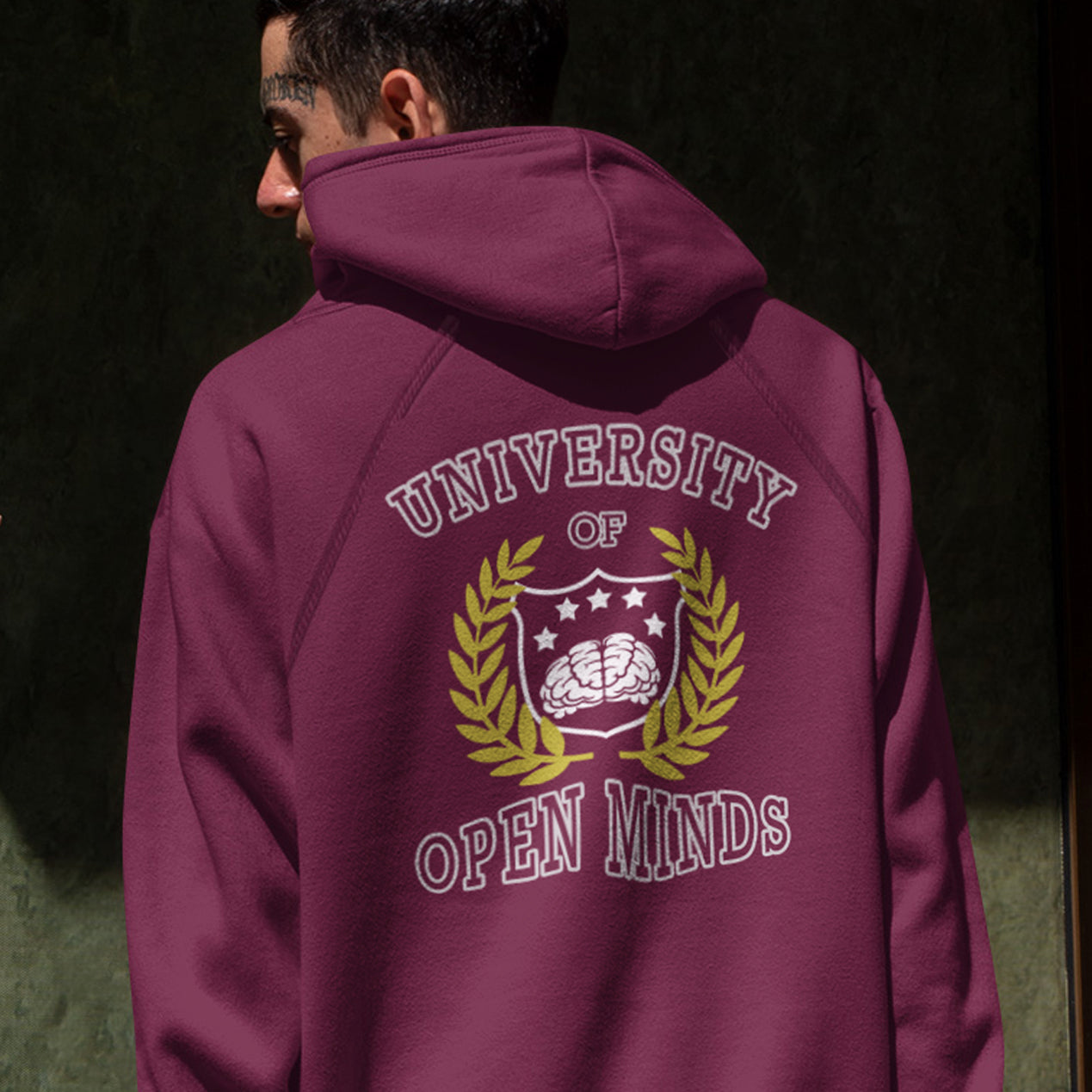 Person wearing a burgundy hoodie with 'University of Open Minds' design on the back. A fake university hoodie design for the liberal minded. If you think outside the box then this university is for you. Only practical lessons and no student loan required. Comfortable and practical. It's extra soft and has a convenient front pouch pocket. Made from organic cotton and recycled polyester, this non conformist hoodie is a great eco-friendly choice.