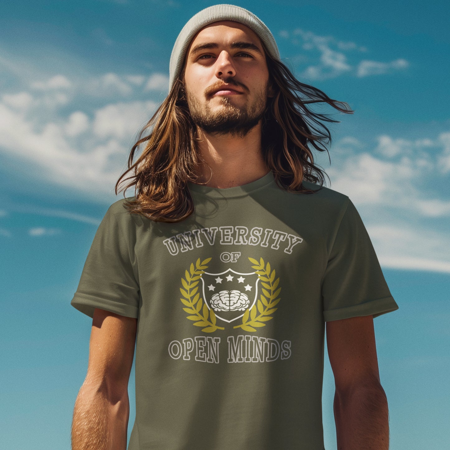 Man wearing a green t-shirt with 'University of Open Minds' design against a blue sky. A cool graphic design for the liberal minded. If you think outside the box then this university is for you. Only practical lessons and no student loan required. Made from 100% organic ring-spun cotton, this social awareness t-shirt is unisex, high-quality, super comfy, and best of all, eco-friendly.
