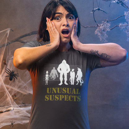 Person wearing a 'Unusual Suspects' t-shirt with a spooky background. A conspiracy theorist t shirt for movie lovers. From bigfoot to aliens, these are the personnel responsible for most cover ups and disputed existences. This imaginative stencil art design is for people who think outside the box. Made from 100% organic ring-spun cotton, this witty conspiracy theory t-shirt is unisex, high-quality, super comfy, and best of all, eco-friendly.