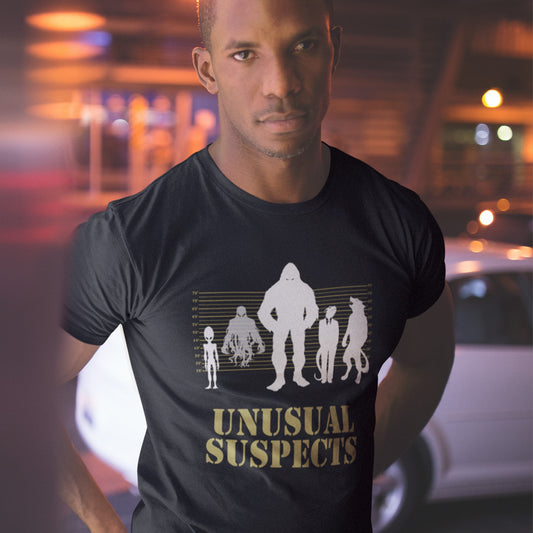 Man wearing a black t-shirt with 'Unusual Suspects' graphic design. A conspiracy theorist t shirt for movie lovers. From bigfoot to aliens, these are the personnel responsible for most cover ups and disputed existences. This imaginative stencil art design is for people who think outside the box. Made from 100% organic ring-spun cotton, this witty conspiracy theory t-shirt is unisex, high-quality, super comfy, and best of all, eco-friendly.