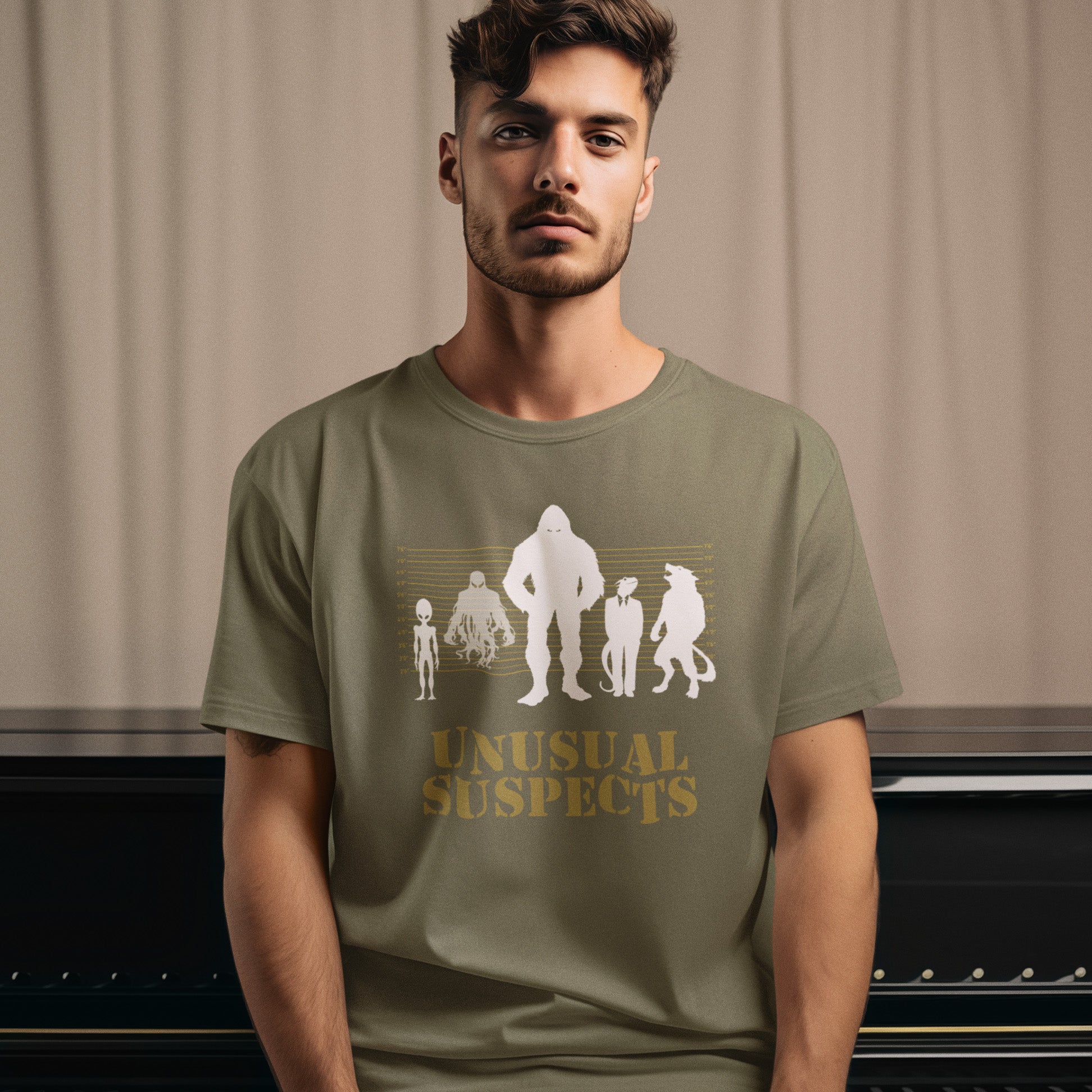 Man wearing a khaki t-shirt with 'Unusual Suspects' graphic design. A conspiracy theorist t shirt for movie lovers. From bigfoot to aliens, these are the personnel responsible for most cover ups and disputed existences. This imaginative stencil art design is for people who think outside the box. Made from 100% organic ring-spun cotton, this witty conspiracy theory t-shirt is unisex, high-quality, super comfy, and best of all, eco-friendly.
