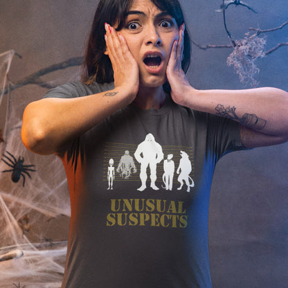 Person wearing a 'Unusual Suspects' t-shirt with a Halloween-themed background. A design for movie loving conspiracy theorists. From bigfoot to aliens, these are the personnel responsible for most cover ups and disputed existence. This imaginative stencil art is truly for people who think outside the box. Made from 100% organic ring-spun cotton, this witty conspiracy theory t-shirt is unisex, high-quality, super comfy, and best of all, eco-friendly.