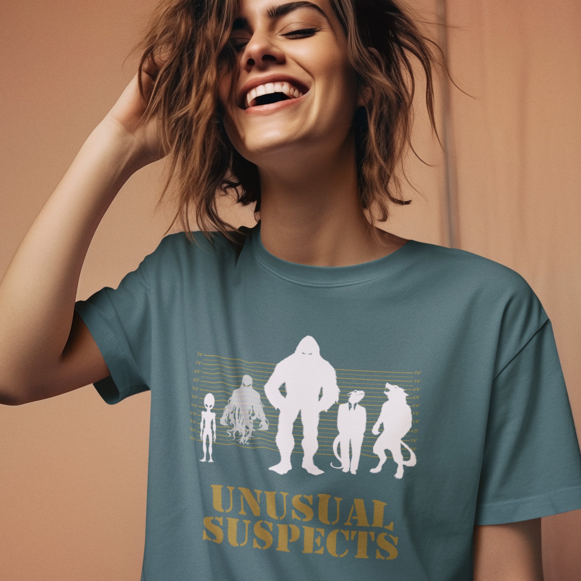 Woman wearing a blue t-shirt with 'Unusual Suspects' graphic design on a beige background. A design for movie loving conspiracy theorists. From bigfoot to aliens, these are the personnel responsible for most cover ups and disputed existence. This imaginative stencil art is truly for people who think outside the box. Made from 100% organic ring-spun cotton, this witty conspiracy theory t-shirt is unisex, high-quality, super comfy, and best of all, eco-friendly.