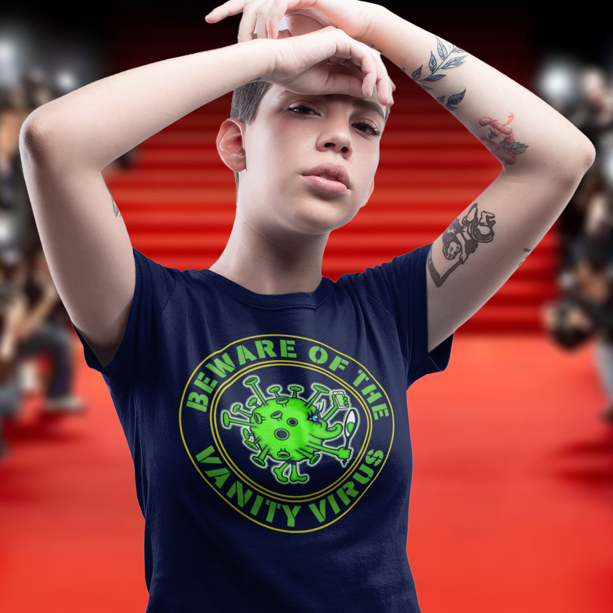 Person wearing a t-shirt with a graphic design and text, standing on a red carpet. This satirical counter culture t shirt suggest that vanity actually makes you ugly. This unique t-shirt design promotes social awareness of the dangers of vanity, and how it's a bitch once it takes hold. Made from 100% organic ring-spun cotton, this funny counter culture t shirt is unisex, high-quality, super comfy, and best of all, eco-friendly.